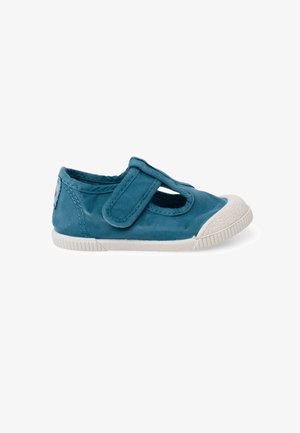 Zapato azul para niño pequeño con punta y suela de goma blanca, con una sola tira ajustable de cierre de velcro en la parte superior.