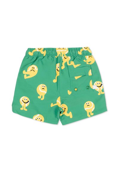 Shorts de bain verts pour enfants avec ceinture élastique, personnages de balles de tennis jaunes souriantes et tristes partout, et une poche arrière avec rabat et œillets.