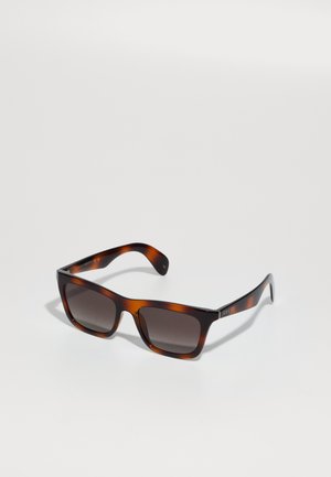 Óculos de sol tortoiseshell castanhos com lentes escuras, armação quadrada e hastes elegantes com um detalhe do logotipo em prata. Material de plástico suave.
