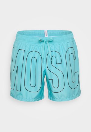 Costumi da bagno turchesi con grandi lettere nere che scrivono "MOSC." Presentano una cintura elastica con un cordino per la regolazione.