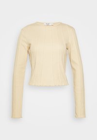 Beige randig långärmad crop top med scallop-kant och rund halsringning, uppvisad mot en enkel vit bakgrund.