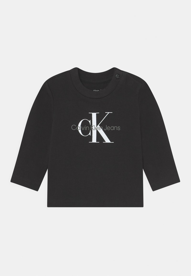 T-shirt noir à manches longues en coton avec un col rond, arborant un logo blanc Calvin Klein Jeans imprimé sur le devant.