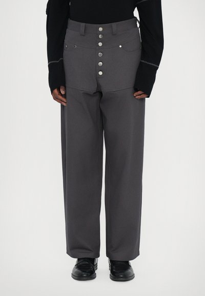Pantalons larges gris avec une taille haute, poches plaquées à l'avant et une braguette à boutons, fabriqués à partir d'un tissu robuste avec une texture lisse.
