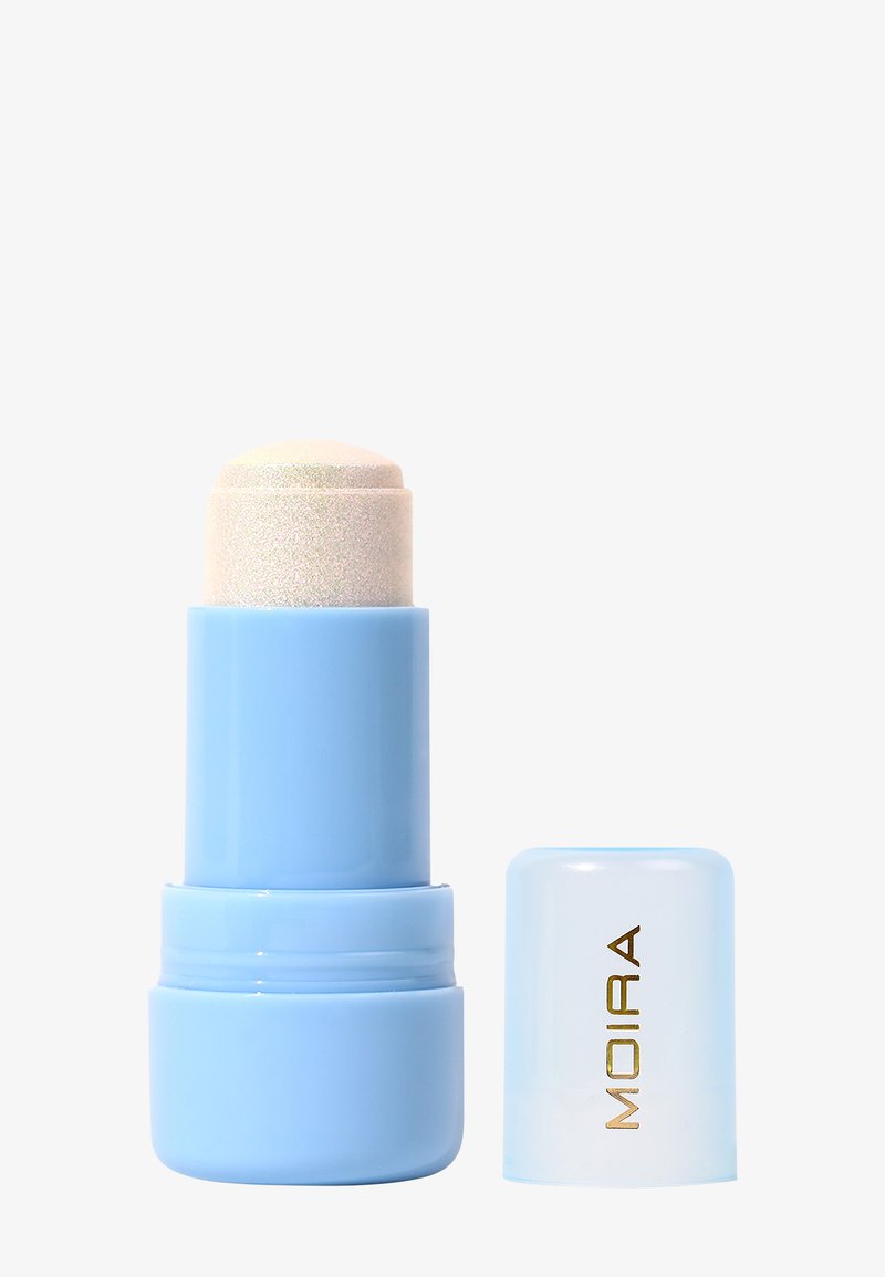 Bâton de maquillage bleu clair avec produit beige étendu, à côté d'un capuchon translucide portant l'inscription « MOIRA » en lettres dorées.