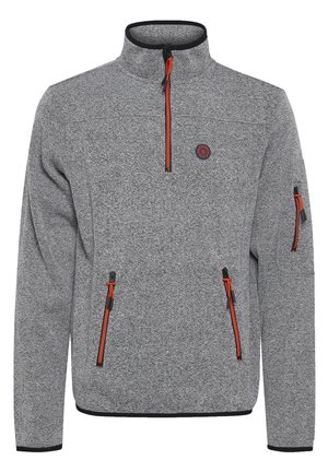 Sudadera de forro polar gris con media cremallera y acentos negros, con tiradores de cremallera naranjas y dos bolsillos laterales con cremallera. Logotipo circular en el pecho.