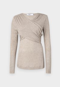Beige långärmad topp i mjukt, texturerat tyg; har en omslagsdesign med veckdetaljer vid axlarna och en rundad halsringning.
