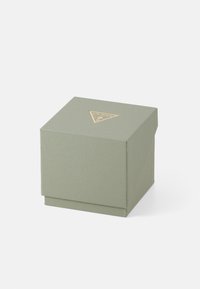 Grüne strukturierte Pappbox mit einem goldenen, dreieckigen Logo auf der Oberseite, ausgestattet mit einem Deckel zum Umklappen und in quadratischer Form.