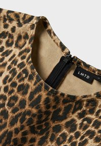 Top de estampado de leopardo hecho de tela texturizada, con escote redondo y cierre de cremallera negra en la parte posterior con una etiqueta marcada 'LMTD'.