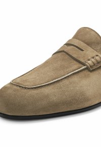 Mocassin en daim marron clair avec une semelle noire basse et un détail de sangle sur le dessus, présenté en vue latérale.
