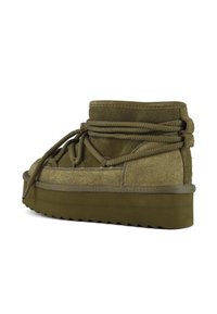 Botas de tobillo de ante verde oliva con acabado texturizado, suela de plataforma gruesa y cordones anudados. El detalle de la suela en zigzag mejora el agarre.