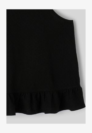 Haut noir sans manches avec ourlet à volants en tissu doux sur un fond clair.