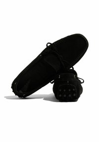 Schwarze Wildleder-Slipper mit runder Zehenform, Schnürsenkeln und Gummisohle mit Noppen. Auffällige Nähte und glatte Textur.