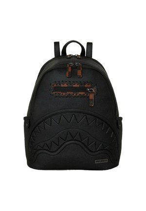 Mochila negra de cuero texturizado, con un diseño elevado de dientes de tiburón, acentos de cremallera marrón y correas ajustables.