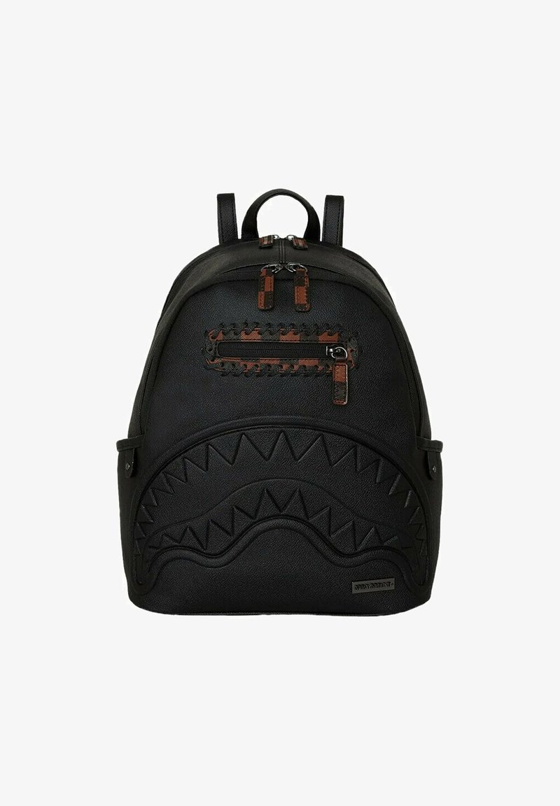 Zaino nero realizzato in pelle texturizzata, caratterizzato da un design a denti di squalo in rilievo, dettagli con cerniere marroni e spallacci regolabili.