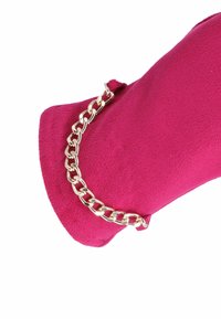 Clutch in finta pelle scamosciata fucsia con un accento in catena metallica dorata, caratterizzato da una forma elegante e arrotondata e una texture morbida.