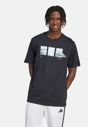 Zwart katoenen t-shirt met een grafische print van vier teal afbeeldingen met geometrische vormen. Korte mouwen en een ronde hals.