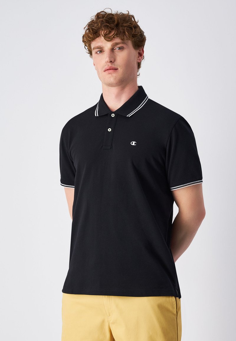 Czarna koszulka polo z krótkim rękawem, białym kołnierzykiem i paskami na rękawach, wykonana z gładkiego materiału, z delikatnym logo marki na piersi.