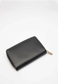 Portafoglio in pelle nera con chiusura a zip, texture liscia, forma rettangolare e un accento metallico in tono oro sul tirante della zip.