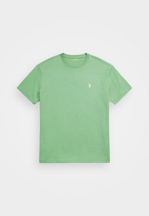 Camiseta de algodón verde con un cuello redondo, mangas cortas y un pequeño logo bordado en blanco en el lado izquierdo del pecho. Textura suave, diseño sencillo.