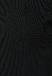 Maglione nero a coste con linee verticali e un motivo testurizzato, dal design aderente e in tessuto a maglia liscia.