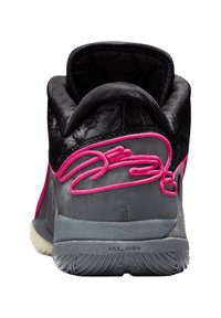 Zapato negro de media caña con parte superior texturizada, costuras decorativas en rosa, suela exterior gris y cuello acolchado para mayor comodidad. Presenta un detalle de logotipo en la parte trasera.