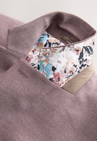 Textureret lavendelfarvet skjorte med en mønstret indre krave med blomsterprint i nuancer af pink, blå og creme. Letvægtsmateriale og struktureret design.