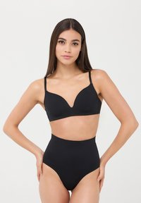 Set di lingerie nera composto da un reggiseno a scollatura profonda con spalline regolabili e culotte a vita alta, texture liscia e design minimalista.