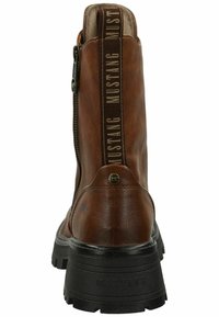 Stivaletto in pelle marrone con cerniera laterale, superficie texture e suola in gomma nera con dettagli del logo sul tallone.