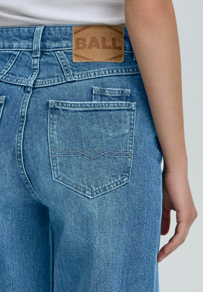 Svetlomodré rifľové nohavice s vysokým pásom, s veľkým zadným vreckom, prešitým detailom a hnedou koženou štítkou s logom "BALL".