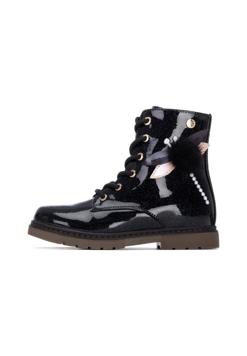 Botín negro brillante con un acabado brillante, ojales dorados, cordones negros y acentos decorativos, que incluyen plumas y un pom-pom.
