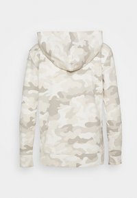 Felpa con cappuccio in un motivo camouflage beige, realizzata in tessuto morbido, con maniche lunghe e una vestibilità rilassata. Vista posteriore.