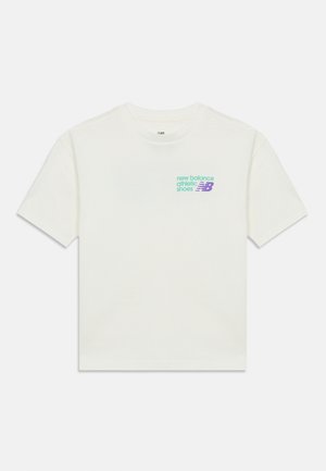 Camiseta blanca de cuello redondo con mangas cortas y pequeño logo de zapatos deportivos New Balance en verde y púrpura en el pecho izquierdo.