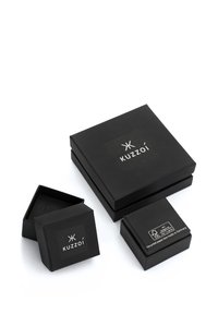 Black cardboard boxes in varying sizes, featuring a logo and labels. Smooth texture with matte finish. Recycled paper construction indicated.