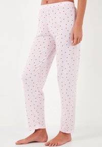 Light pink pajama pants with a soft texture, featuring a small red heart print throughout, and an elastic waistband for comfort.