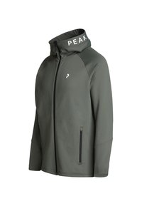 Grön sportjacka med hög krage, dragkedja och sidofickor. Har "PEAK"-logotypen på kragen och ett jämnt, texturerat tyg.