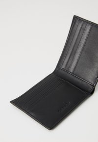 Portefeuille en cuir noir avec plusieurs emplacements pour cartes, texture lisse et design minimaliste. Présente un logo de marque en relief. Vue ouverte.