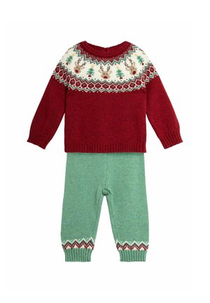Roter gestrickter Pullover mit festlichem Muster-Rundhalsausschnitt in Creme, Grün und Rot; kombiniert mit grünen strukturierten Hosen mit gemusterten Säumen.