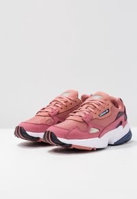 Sneaker in suede e mesh rosa con suola spessa bianca e nera, dotate di un design con lacci e discreto marchio sul lato.