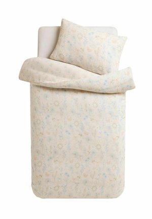 Einzelbett mit hellbeiger Bettdecke mit Blumenmuster und passendem Kissen auf einem weißen Spannbettlaken.