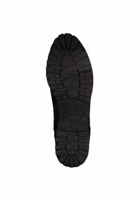 Semelle de chaussure en caoutchouc noir avec un motif texturé pour une adhérence optimale. Elle présente une forme ronde avec des rainures et des crêtes pour une meilleure prise.