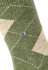 Calzino verde e beige con motivo a diamante, caratterizzato da un'etichetta logo argentata e dettagli in cucitura bianca. Tessuto a maglia testurizzato.
