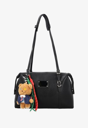 Czarna skórzana torebka na podwójnych paskach na ramię, z metalową płytką z przodu oraz brelokiem w kształcie misia w niebieskiej kurtce i w paskowaną krawat przyczepionym na pierścieniu.