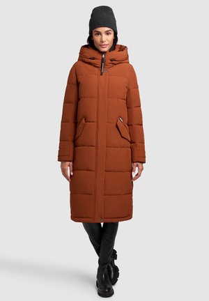 Brown puffer coat with a hood, featuring a quilted design and front pockets. Paired with black fitted pants and a dark knit beanie.