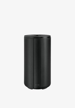 Musta sylinterimäinen Bose-kaiutin, jossa on rei'itetty suojaverkko ja päällä säätönuppi, pystyssä valkoisella taustalla.