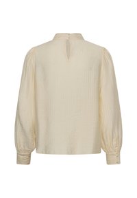 Blouse crème à manches longues avec manches bouffantes, poignets boutonnés et petite fermeture en forme de trou de serrure avec deux boutons au dos du col.