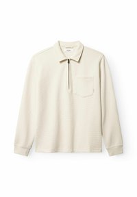 Beige hosszú ujjú, galléros póló, félcipzárral az elején, texturált anyaggal és mellzsebbe. Puha, bordázott mandzsetták az ujjaknál.