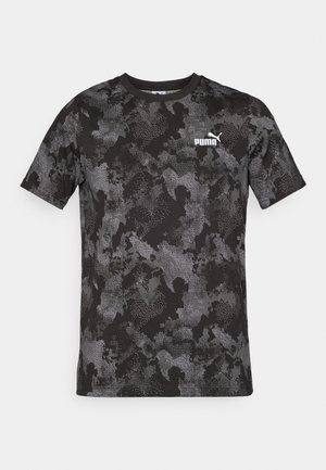 Camiseta negra de manga corta con un patrón de camuflaje en tonos de gris. Incluye un logo blanco de Puma en el pecho. Textura de tela suave.