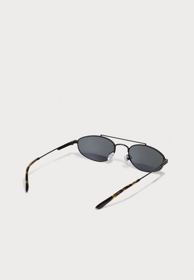 Lunettes de soleil noires en forme d'ovale avec des verres gris, monture en métal fin et branches en acétate à motif écaille de tortue. Tampons de nez réglables inclus.