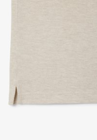 Ljus beige bomullstyg med en texturerad yta; har sidofållar i nederkant för ökad rörlighet. Enkelt, stilrent design.