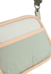Borsa imbottita verde e bianca con accenti rosa, caratterizzata da un logo prominente, hardware in metallo e texture liscia. Manico regolabile.